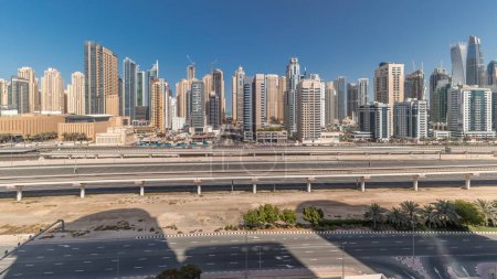 Téléchargez les photos : Panorama montrant les gratte-ciel de Dubai Marina et la route Cheikh Zayed avec métro aérien. Trafic sur une autoroute près des tours modernes, Émirats arabes unis - en image libre de droit