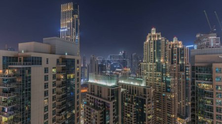 Téléchargez les photos : Panorama du centre-ville de Dubaï nuit aérienne. Skyline urbaine de la baie d'affaires avec des gratte-ciel modernes et des tours chantier de construction d'en haut - en image libre de droit
