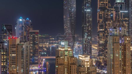 Foto de Rascacielos de Dubai Marina con los edificios residenciales más altos iluminados transición día a noche después de la puesta del sol. Vista aérea desde el distrito JLT - Imagen libre de derechos