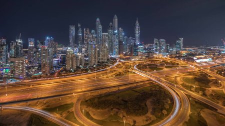 Foto de Panorama de Dubai Marina mostrando la noche de cruce de espaguetis de intersección de carreteras. Rascacielos más altos iluminados sobre un fondo. Vista aérea desde el distrito JLT. - Imagen libre de derechos