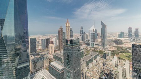 Foto de Panorama que muestra muchos rascacielos futuristas en el centro de negocios del distrito financiero en Dubai en la carretera Sheikh Zayed. Vista aérea desde arriba con nubes - Imagen libre de derechos