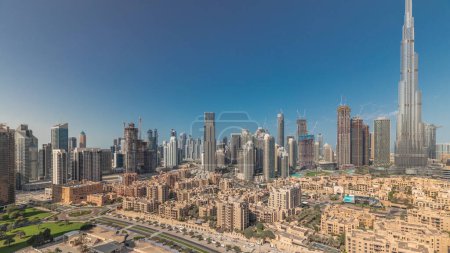 Téléchargez les photos : Panorama montrant la baie d'affaires de Dubaï et les tours du centre-ville le matin. Vue sur le toit de certains gratte-ciels et de nouveaux bâtiments en construction avec des maisons thaditionnelles du vieux quartier de la ville - en image libre de droit