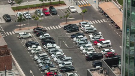 Téléchargez les photos : Vue aérienne d'un parking avec de nombreuses voitures en rangées. Espace de remplissage pendant la journée de travail près des immeubles de bureaux - en image libre de droit