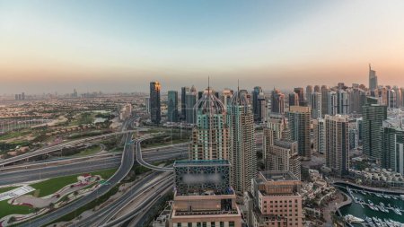 Foto de Panorama que muestra el puerto deportivo de Dubái y los rascacielos JLT a lo largo de Sheikh Zayed Road con gran cruce cerca del campo de golf y la antena del distrito de la ciudad de medios. Edificios residenciales y de oficinas desde arriba. - Imagen libre de derechos