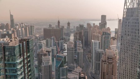 Téléchargez les photos : Vue panoramique Skyline de Dubai Marina montrant un canal artificiel entouré de gratte-ciel le long du rivage pendant toute la journée aérienne avec des ombres se déplaçant rapidement. Yachts et bateaux flottants. DUBAI, EAU - en image libre de droit