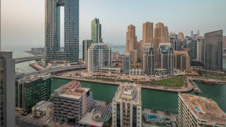 Téléchargez les photos : Panorama montrant Dubai Marina avec plusieurs bateaux et yachts garés dans le port et gratte-ciel autour du canal aérien. Tours du quartier JBR sur fond - en image libre de droit