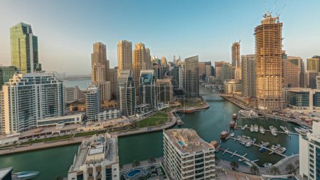 Foto de Panorama que muestra los rascacielos Dubai Marina y el distrito JBR con edificios de lujo y resorts aéreos. Frente al mar con palmeras y barcos flotando en el canal - Imagen libre de derechos