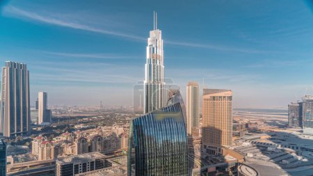 Foto de Panorama aéreo del centro de Dubái con centro comercial y tráfico en una calle durante todo el día desde arriba, Emiratos Árabes Unidos Rascacielos modernos y hoteles con sombras que se mueven rápido - Imagen libre de derechos