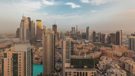 Téléchargez les photos : Panorama montrant l'horizon panoramique aérien d'une grande ville futuriste au coucher du soleil. Business bay et Downtown district avec gratte-ciel et maisons traditionnelles, Dubaï, Émirats arabes unis - en image libre de droit