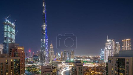 Photo for Dubai Downtown panoramic cityscape with tallest skyscrapers around aerial day to night transition. Construction site of new towers and busy roads with traffic from above - Royalty Free Image