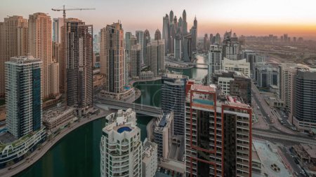 Foto de View of various skyscrapers in tallest recidential block in Dubai Marina aerial night to day transition panoramic with artificial canal. Many towers in JBR district and yachts before sunrise - Imagen libre de derechos
