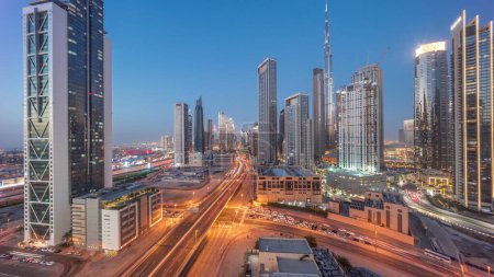 Téléchargez les photos : Vue panoramique aérienne du centre-ville de Dubaï avec de nombreuses tours intemporelles de transition de jour à nuit. Zone d'affaires dans la ville urbaine intelligente. gratte-ciel et gratte-ciel d'en haut après le coucher du soleil, Émirats arabes unis. - en image libre de droit