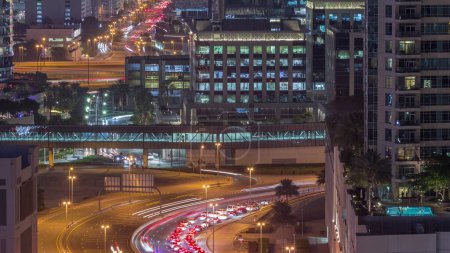 Photo for Top aerial view of busy road intersection and traffic junctions in downtown Dubai city night timelapse. Modern construction design of crossroads and highways to avoid traffic jams. Many driving cars - Royalty Free Image