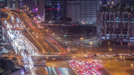 Photo for Top aerial view of busy road intersection and traffic junctions in Dubai city night timelapse. Modern construction design of crossroads and highways to avoid traffic jams. Driving cars in Business bay - Royalty Free Image