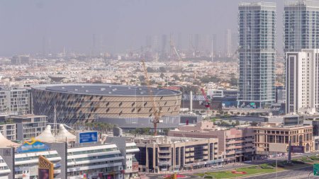 Photo for Aerial view to Dubai City Walk district and construction site timelapse. New modern part with low rise buildings and villas created as European-style streets. Cargo sea port on a background - Royalty Free Image