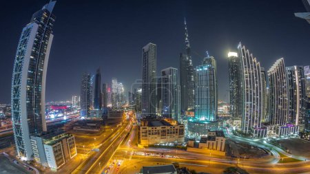 Photo for Aerial panorama of Dubai Downtown skyline with many illuminated towers night timelapse. Business area traffic in smart urban city. Skyscraper and high-rise buildings from above, UAE. - Royalty Free Image