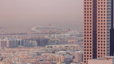 Foto de Vista aérea de casas de apartamentos y villas en la ciudad de Dubai cerca del timelapse del centro. Puerto marítimo sobre fondo. Emiratos Árabes Unidos - Imagen libre de derechos