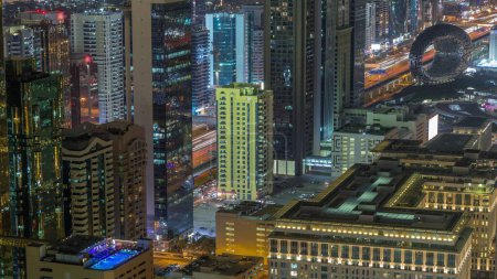 Foto de Vista del horizonte de los edificios de gran altura en Sheikh Zayed Road en Dubai timelapse noche aérea, Emiratos Árabes Unidos. Rascacielos iluminados y museo en el Centro Financiero Internacional desde arriba - Imagen libre de derechos