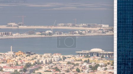 Téléchargez les photos : Vue aérienne des maisons d'appartements et villas dans la ville de Dubaï près du centre-ville timelapse. Bâtiments en construction avec grues sur l'île. Émirats arabes unis - en image libre de droit