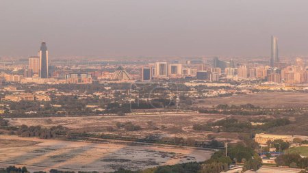 Foto de Bur Dubai y Deira distritos timelapse aérea visto desde el distrito financiero. Edificios ubicados a lo largo de Dubai Creek. Sombras largas y luz cálida durante la puesta del sol - Imagen libre de derechos