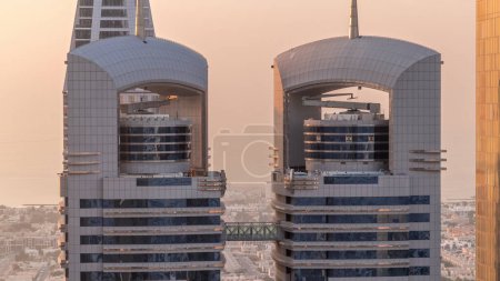 Téléchargez les photos : Vue rapprochée des immeubles de grande hauteur sur Sheikh Zayed Road à Dubaï timelapse aérien, EAU. Les gratte-ciels haut dans le hub financier de la place financière internationale d'en haut pendant le coucher du soleil - en image libre de droit