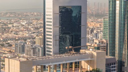 Téléchargez les photos : Piscine sur le toit au sommet du gratte-ciel près de Sheikh Zayed Road à Dubaï timelapse aérien, Émirats arabes unis. Tours dans le centre financier international d'en haut et maisons de villa derrière elle le soir - en image libre de droit
