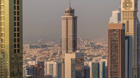 Téléchargez les photos : Vue aérienne des immeubles de grande hauteur sur Sheikh Zayed Road à Dubaï timelapse aérien pendant le coucher du soleil EAU. gratte-ciel dans le Centre financier international d'en haut. Nombreuses villas et maisons sur fond - en image libre de droit