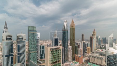 Foto de Vista del horizonte de los edificios de gran altura en Sheikh Zayed Road en Dubai timelapse panorámica aérea, Emiratos Árabes Unidos. Rascacielos en el centro financiero internacional desde arriba con cielo nublado - Imagen libre de derechos