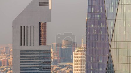 Foto de Dubai World Trade Centre en el Sheikh Zayed Road detrás de las torres de oficinas en el distrito financiero timelapse aéreo desde arriba. Bur Dubai distrito con pequeñas casas en un fondo - Imagen libre de derechos