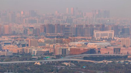 Téléchargez les photos : Bur Dubai et Deira districts timelapse aérienne vue du quartier financier. Bâtiments situés le long du ruisseau Dubai. Grues sur chantier et circulation sur le passage supérieur - en image libre de droit