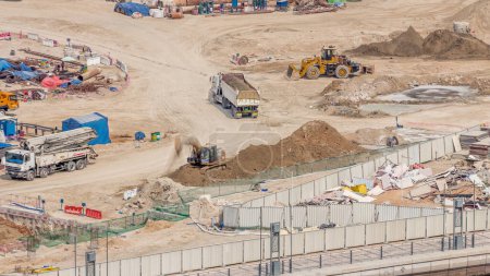 Foto de Fosa de cimentación para la construcción del edificio del complejo de apartamentos timelapse aéreo. Instalación profunda y excavación con maquinaria pesada como excavadoras, excavadoras y camiones, Dubai - Imagen libre de derechos