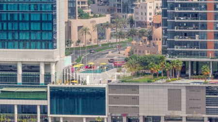 Téléchargez les photos : Promenade à pied le long du canal d'eau dans le quartier Business Bay Dubaï timelapse aérienne. Piscine sur le toit et restaurants. Ponts au-dessus du front de mer avec gratte-ciel d'en haut, Émirats arabes unis - en image libre de droit
