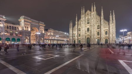 Téléchargez les photos : Panorama showing Milan Cathedral and historic buildings night timelapse. Duomo di Milano is the cathedral church located at the Piazza del Duomo square in Milan city in Italy - en image libre de droit