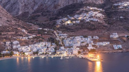 Photo for Amorgos island aerial day to night transition timelapse from above after sunset. Traditional Greece - illuminated white houses on hills and turquoise sea, Cyclades - Royalty Free Image