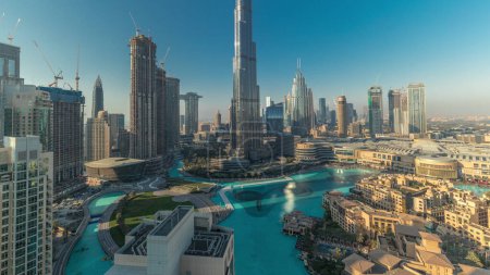 Foto de Vista aérea de la ciudad de Dubai durante todo el día timelapse en el centro con sombras se mueve rápido. skyline futurista de la ciudad con rascacielos y fuente desde arriba. - Imagen libre de derechos