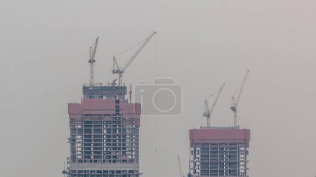 Foto de Grúas que trabajan en obras modernas sitio de restricción de los nuevos rascacielos timelapse. Rápida actividad urbanística de construcción y construcción - Imagen libre de derechos