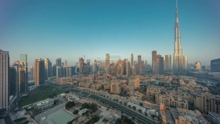 Téléchargez les photos : Dubaï Timelapse du centre-ville avec le soleil reflété par le plus haut gratte-ciel et d'autres tours avec une vue ombragée depuis le sommet pendant le lever du soleil, Émirats arabes unis. Maisons traditionnelles de la vieille ville - en image libre de droit