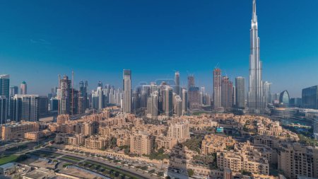 Téléchargez les photos : Dubaï Panorama matinal du centre-ville avec le soleil reflété par le plus haut gratte-ciel et d'autres tours vue du haut pendant le lever du soleil avec de longues ombres se déplaçant rapidement, Émirats arabes unis. Maisons traditionnelles - en image libre de droit