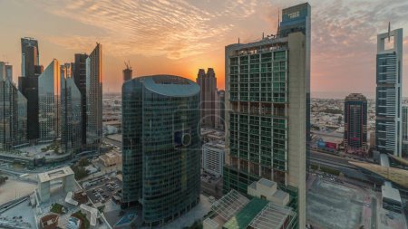 Foto de Puesta de sol sobre los rascacielos del centro financiero internacional de Dubái timelapse aéreo. Vista panorámica con cielo nublado - Imagen libre de derechos