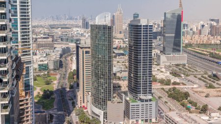 Téléchargez les photos : Vue aérienne de la ville des médias et du quartier des hauteurs al barsha timelapse pendant toute la journée depuis la marina de Dubaï. Tours et gratte-ciel avec des ombres se déplaçant rapidement et la circulation sur une autoroute d'en haut - en image libre de droit