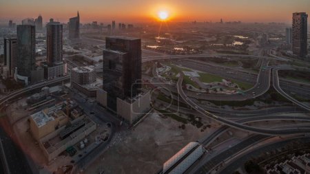 Photo for Aerial panoramic view of media city and al barsha heights district with golf course timelapse from Dubai marina during sunrise. Towers and skyscrapers with traffic on a highway crossroad from above - Royalty Free Image
