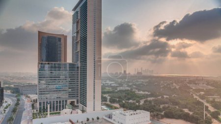 Photo for Sunrise in Dubai International Financial district transition timelapse. Aerial view of business office towers at morning. Skyscrapers with hotels near downtown - Royalty Free Image