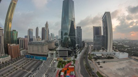 Téléchargez les photos : Panorama du quartier financier international de Dubaï timelapse. Vue aérienne des tours de bureaux d'affaires au lever du soleil. gratte-ciel lumineux avec hôtels et centres commerciaux près du centre-ville - en image libre de droit