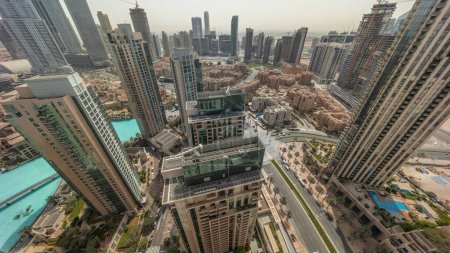 Foto de Vista panorámica aérea con salida del sol sobre la gran ciudad futurista. Bahía de negocios y distrito centro con rascacielos y sombras moviéndose rápido durante todo el día, Dubai, Emiratos Árabes Unidos skyline. - Imagen libre de derechos