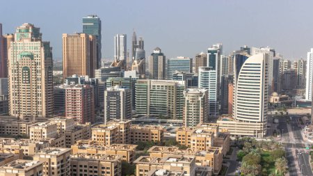 Téléchargez les photos : Des gratte-ciel dans le quartier de Barsha Heights et des immeubles de faible hauteur dans le quartier des Verts se succèdent toute la journée. Skyline de Dubaï avec palmiers et arbres. Ombres se déplaçant rapidement - en image libre de droit