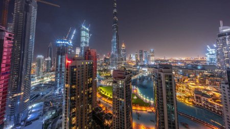 Foto de Dubai Centro de paisaje urbano con los rascacielos más altos alrededor de timelapse panorámica aérea durante toda la noche. Sitio de construcción de nuevas torres y carreteras ocupadas con tráfico desde arriba. Luces apagadas - Imagen libre de derechos