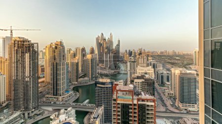 Foto de Panorama mostrando varios rascacielos en el bloque recidencial más alto de Dubai Marina timelapse aéreo con canal artificial. Muchas torres y yates - Imagen libre de derechos