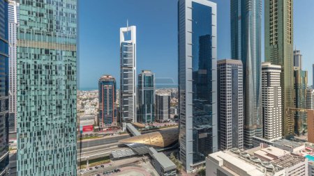Téléchargez les photos : Panorama montrant la vue aérienne du quartier financier international de Dubaï avec de nombreux gratte-ciel timelapse. Trafic sur la route Cheikh Zayed près des tours à plusieurs étages. Dubai, Émirats arabes unis. - en image libre de droit