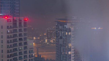 Téléchargez les photos : Maisons de luxe et villas près du canal avec des tours aériennes pendant toute la nuit à Business Bay, Dubaï, Émirats arabes unis. Lac avec route et lumières de la ville skyline - en image libre de droit