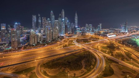 Téléchargez les photos : Panorama du port de plaisance de Dubaï montrant l'intersection des autoroutes nuit de jonction spaghetti. Les gratte-ciel les plus hauts éclairés sur un fond. Vue aérienne du quartier JLT. - en image libre de droit